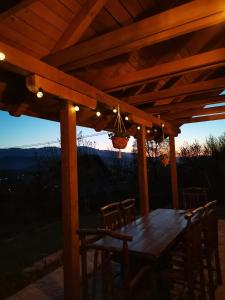 a wooden table and chairs under a wooden pergola at Nektar Park Villa Sara in Bihać