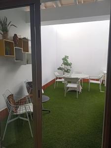 een kamer met een tafel en stoelen en een groen tapijt bij Habitación Privada May in Vecindario