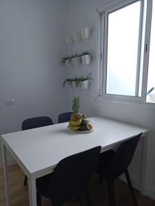 einen weißen Tisch und Stühle in einem Zimmer mit Fenster in der Unterkunft Habitación Privada May in Vecindario