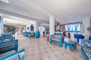 uma sala de espera com cadeiras e mesas azuis em Atheras em Evdilos