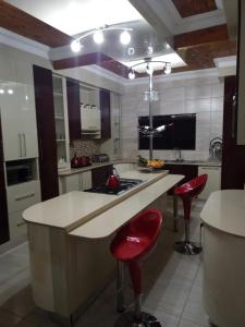 uma cozinha com um balcão e dois bancos de bar vermelhos em KwaNomzi Botique Lodge em Lusikisiki