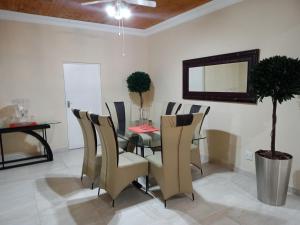 uma sala de jantar com uma mesa, cadeiras e um espelho em KwaNomzi Botique Lodge em Lusikisiki