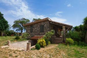 una piccola casa in pietra in mezzo a un campo di Pinnettu Ghilarza a Ghilarza