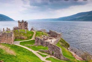 eine Burg am Ufer eines Gewässers in der Unterkunft Immaculate cabin 5 mins to Inverness dogs welcome in Inverness