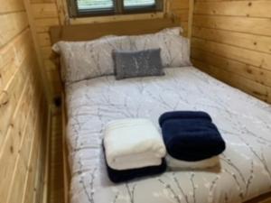 a bed in a tiny house with a blue and white blanket at Immaculate cabin 5 mins to Inverness dogs welcome in Inverness