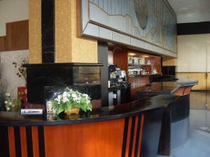 a lobby with a bar with flowers on it at Hotel Oval in Surabaya