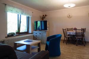 a living room with a couch and a tv and a table at Apartmán Jana in Štiavnické Bane