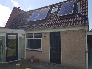een huis met zonnepanelen op het dak bij Knuusje: Knus en Gastvrij! in Vrouwenpolder