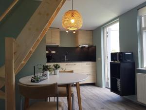 een keuken en eetkamer met een tafel en een trap bij Knuusje: Knus en Gastvrij! in Vrouwenpolder