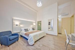 1 dormitorio con 1 cama y 1 silla azul en B&B Gianmarti Suite, en Lecce