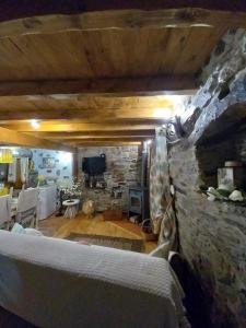 sala de estar con pared de piedra y sofá en Talasnal Casas da Urze TER, en Lousã