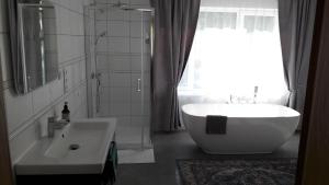 baño con bañera, lavabo y ventana en Blanki Siedlisko agroturystyczne Jestem, en Lidzbark Warmiński