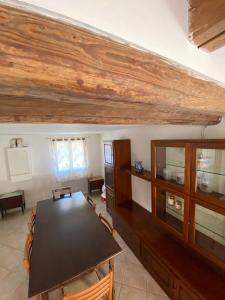 una sala da pranzo con tavolo e soffitto in legno di Il Casale del Miele a Fraforeano