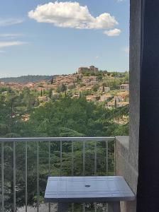 einen Balkon mit einem Tisch und Stadtblick in der Unterkunft Résidence les chênes blancs Appartement T2 in Gréoux-les-Bains