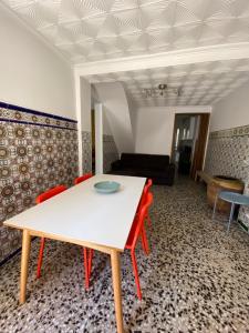 een eetkamer met een tafel en rode stoelen bij Casa Quintero Valencia Playa Cabañal in Valencia