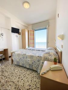 ein Hotelzimmer mit einem Bett und einem Fenster in der Unterkunft Hotel Dinarica in Marotta