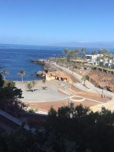 a view of a beach with palm trees and the ocean at Cosy Studio on rooftop Playa Paraiso in Playa Paraiso