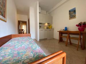 a room with a bed and a table and a kitchen at Eden Appartamenti in Marina di Grosseto