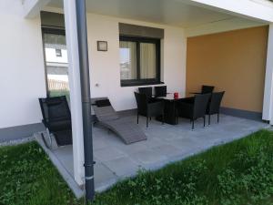 a patio with chairs and a table in a house at Appartement Franz Josef in Aich