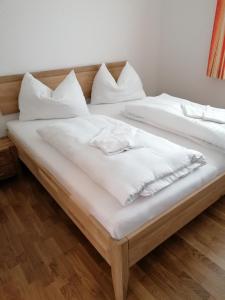 two beds in a room with white sheets and pillows at Appartement Franz Josef in Aich
