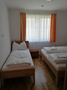 two beds in a small room with a window at Appartement Franz Josef in Aich