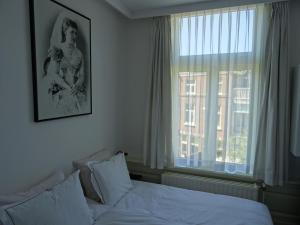 a bedroom with a bed and a large window at Emma's B&B in The Hague