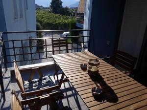 a wooden table and chairs on a balcony with a view at Τhe Diamond in Nea Peramos