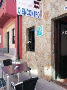 een tafel en stoelen voor een gebouw bij O Encontro in Fisterra