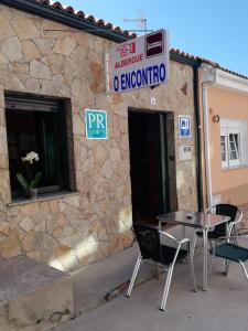 stół i krzesła przed budynkiem w obiekcie O Encontro w mieście Fisterra