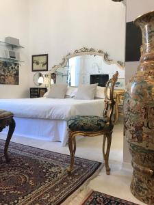 een slaapkamer met een bed met een stoel en een vaas bij Sanctus Syrus 4 in Albenga
