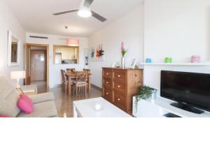 a living room with a couch and a tv and a table at SALTO DE DUNE (Junto al MET y campo de GOLF) in Oliva