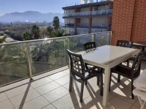 Biały stół i krzesła na balkonie w obiekcie SALTO DE DUNE (Junto al MET y campo de GOLF) w mieście Oliva