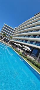 a large apartment building with a large swimming pool at AZ Hôtels Zephyr in Mostaganem