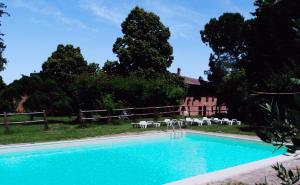 una piscina con sillas y una casa en el fondo en Villa Poggio al Sole Bio Agriturismo private pool, en San Rocco a Pilli