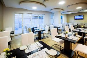 a dining room with tables and white chairs at Al Sarab Hotel in Dubai