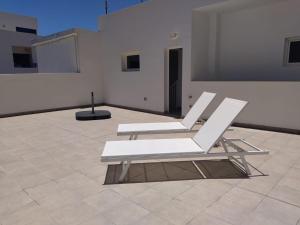 twee witte stoelen op een tegelvloer in een kamer bij Casa Blanca La Restinga in La Restinga