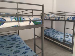 2 Etagenbetten in einem Zimmer mit einem Bett in der Unterkunft Casa Blanca La Restinga in La Restinga