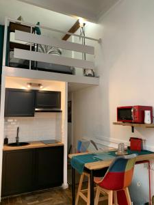 a kitchen with a table and a loft bed at Appartement Cosy Centre Historique Avignon in Avignon