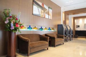 a waiting room with two chairs and a vase of flowers at Hotel Hokke Club Osaka in Osaka