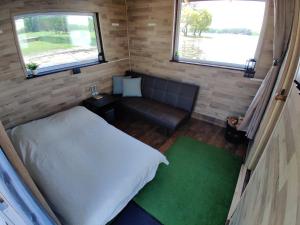 a small bedroom with a bed and a couch at Lämmijärve parvsaun in Värska
