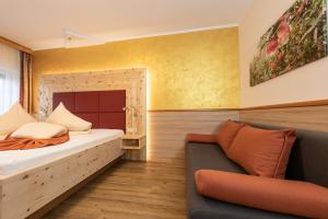 ein Schlafzimmer mit einem Bett und einem Sofa darin in der Unterkunft Thermenhof PuchasPLUS Loipersdorf in Jennersdorf