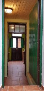 un pasillo vacío con paredes verdes y una puerta en I MITI ViviendaVacacional en Chio