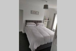 a bedroom with a bed with white sheets and pillows at place by the sea in Bridlington +22 photos