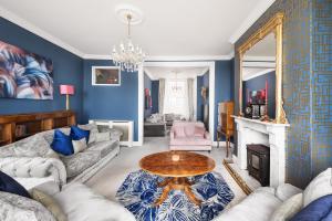 a living room with blue walls and a table at Eastcliff House in Brighton & Hove