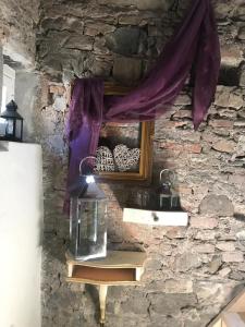 une lanterne en verre sur un mur en pierre avec une fenêtre dans l'établissement Sanctus Syrus 2, à Albenga