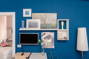 een woonkamer met een blauwe muur en een tv bij Suite contemporanea tra le vie storiche in Moneglia