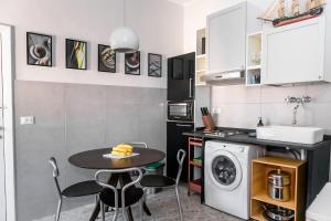 een kleine keuken met een tafel en een wasmachine bij Suite contemporanea tra le vie storiche in Moneglia