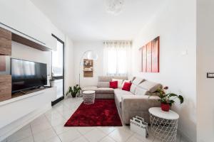 ein Wohnzimmer mit einem Sofa und einem TV in der Unterkunft Sun Terrace Appartment in Lucca