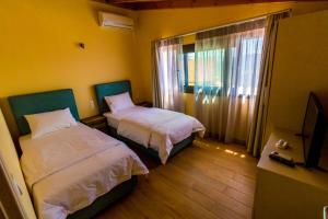um quarto com duas camas e uma televisão e uma janela em Santakira Villas em Parga