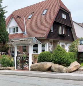 ein Haus mit rotem Dach und einigen Felsen in der Unterkunft Hotel-Pension Teutonia in Braunlage
